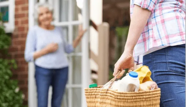 Picture of neighbors helping their elder neighbors with grocery shopping during the covid 19 pandemic