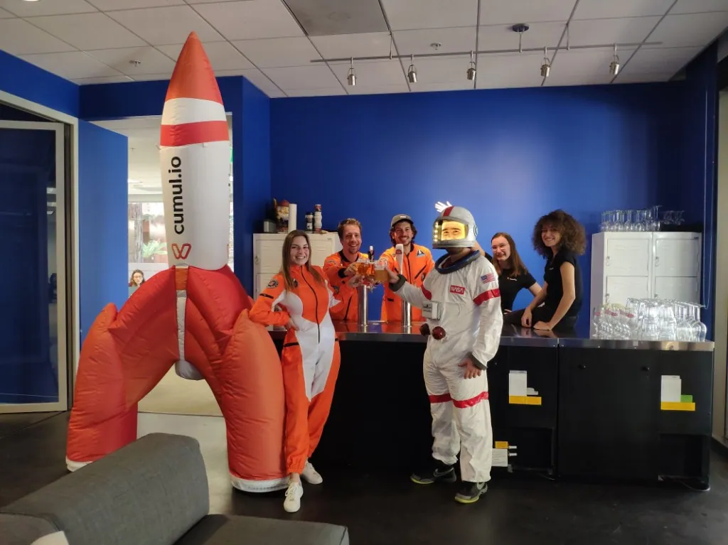 Des membres de l'équipe Luzmo déguisés en astronautes en train de faire la fête au bureau.