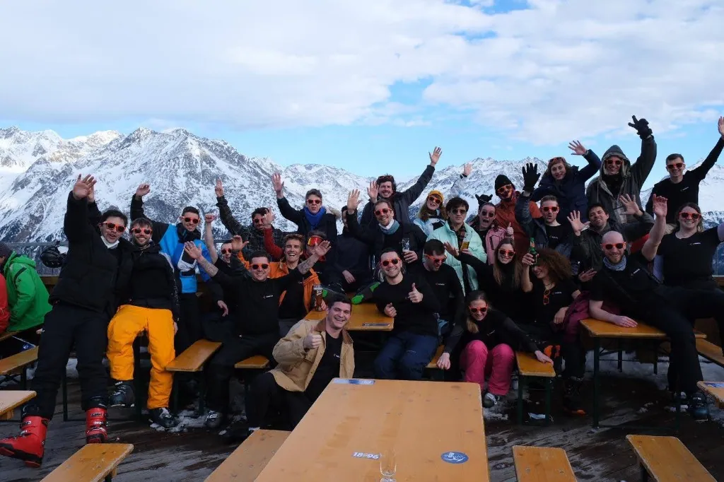 Des membres de l'équipe Luzmo en pleine fête sur une terrasse en montagne lors d'un séjour au ski.